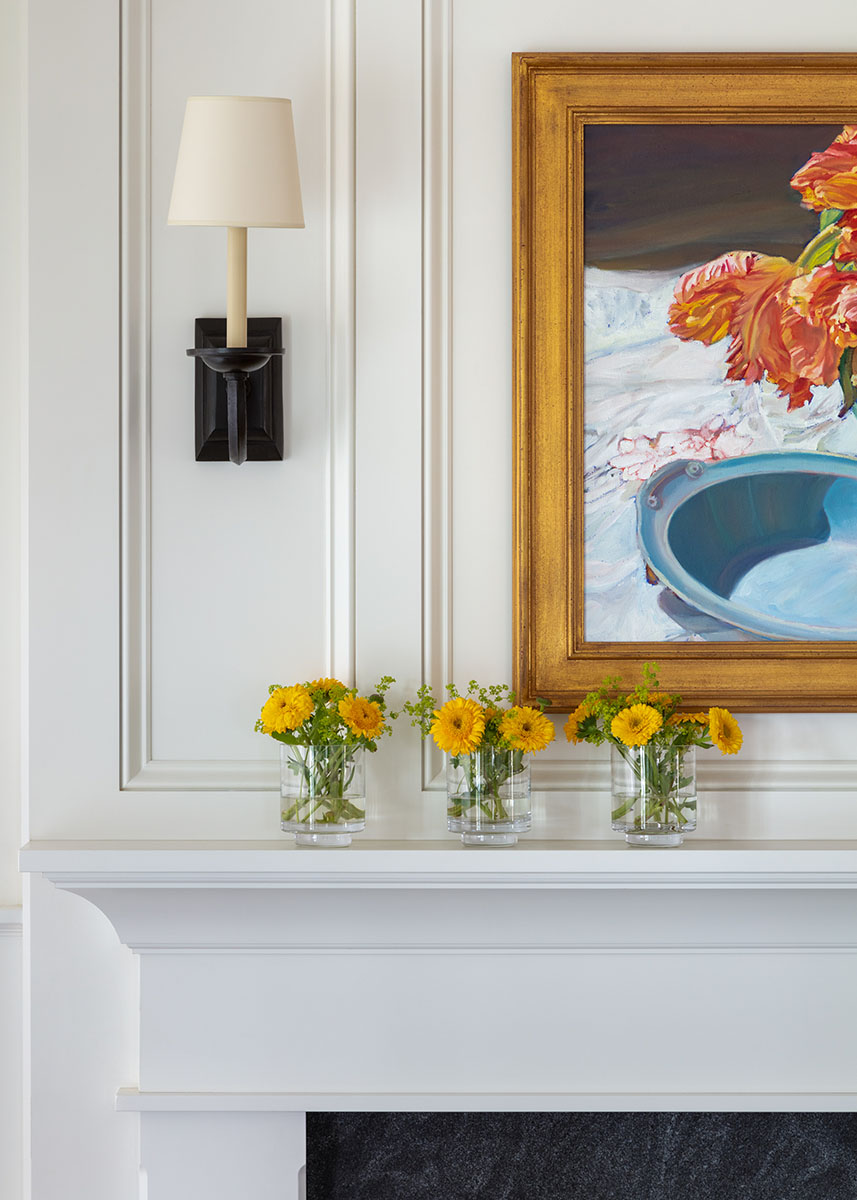 fireplace mantel with sconce and original art