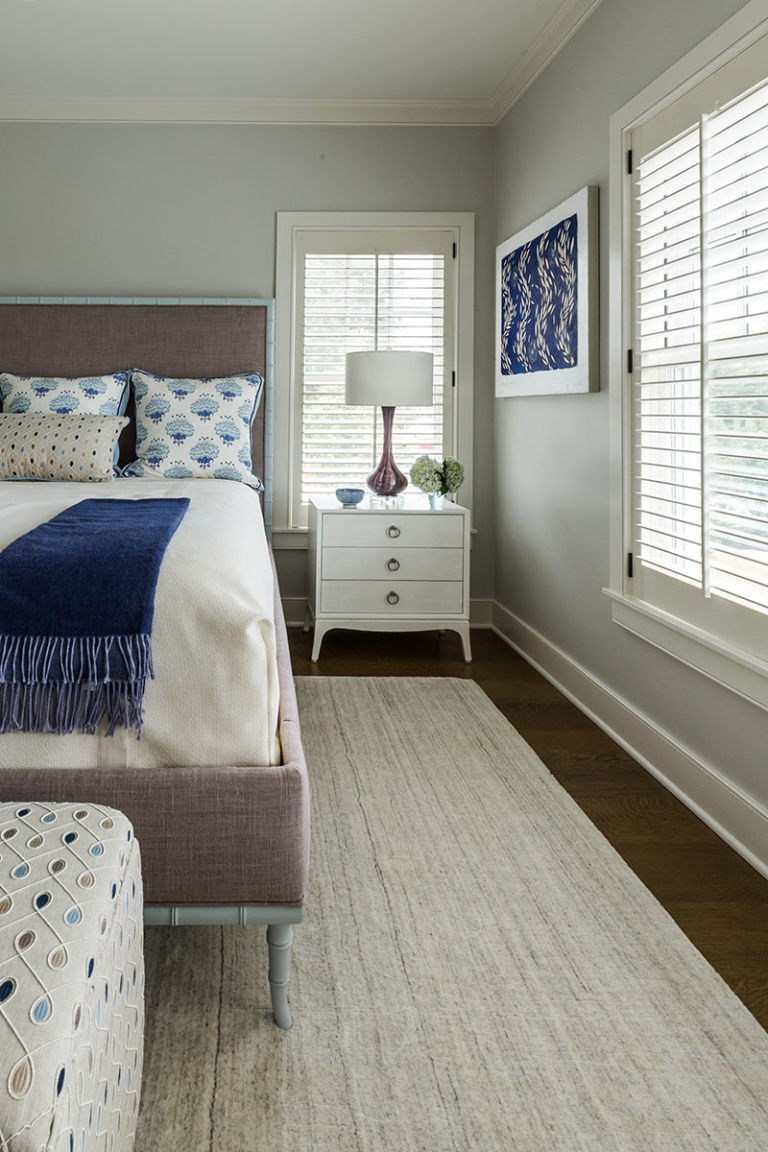 guest bedroom with ottoman and original art
