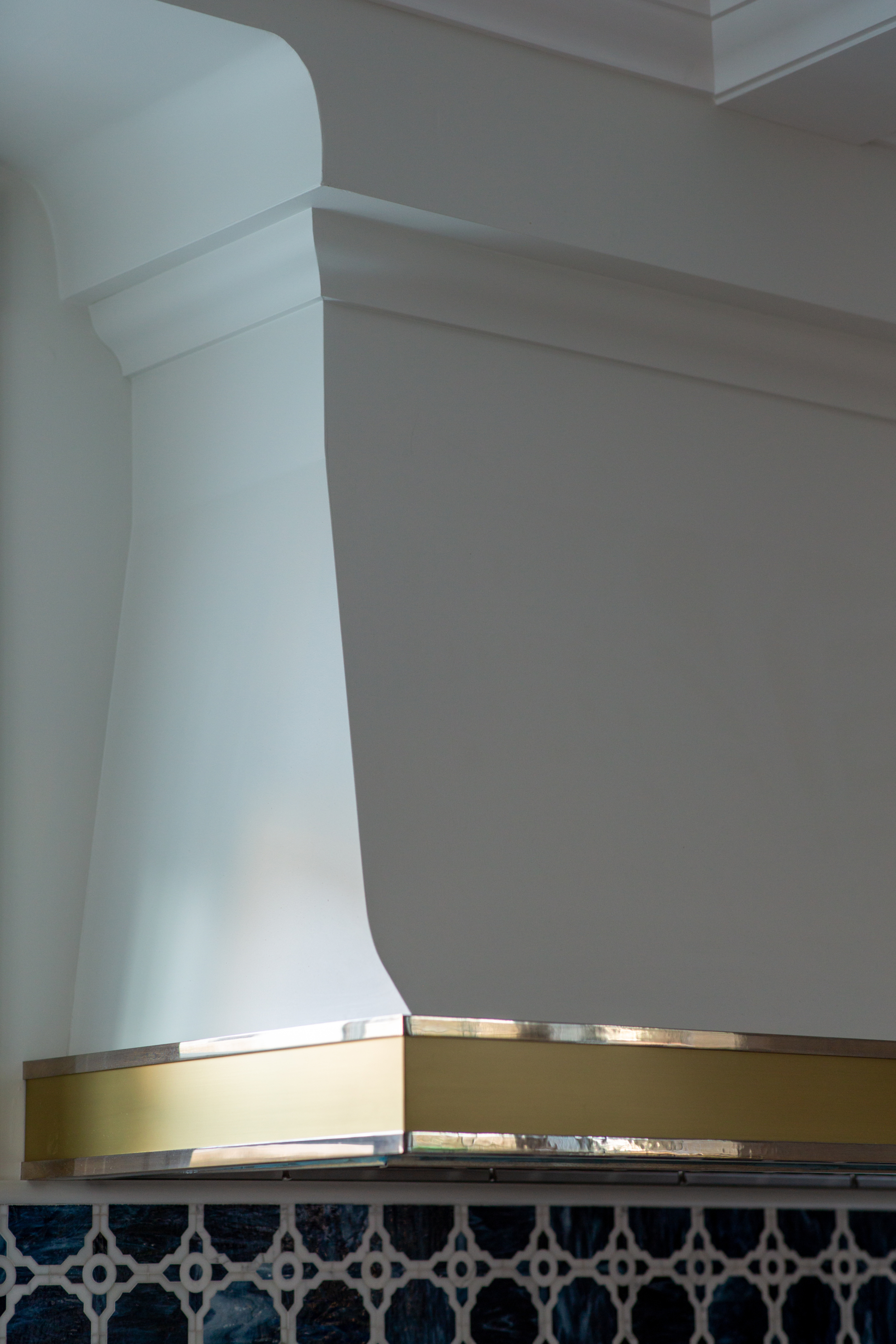 range hood with gold accent over backsplash