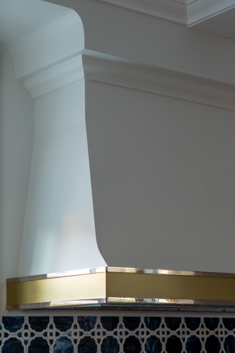 range hood with gold accent over backsplash