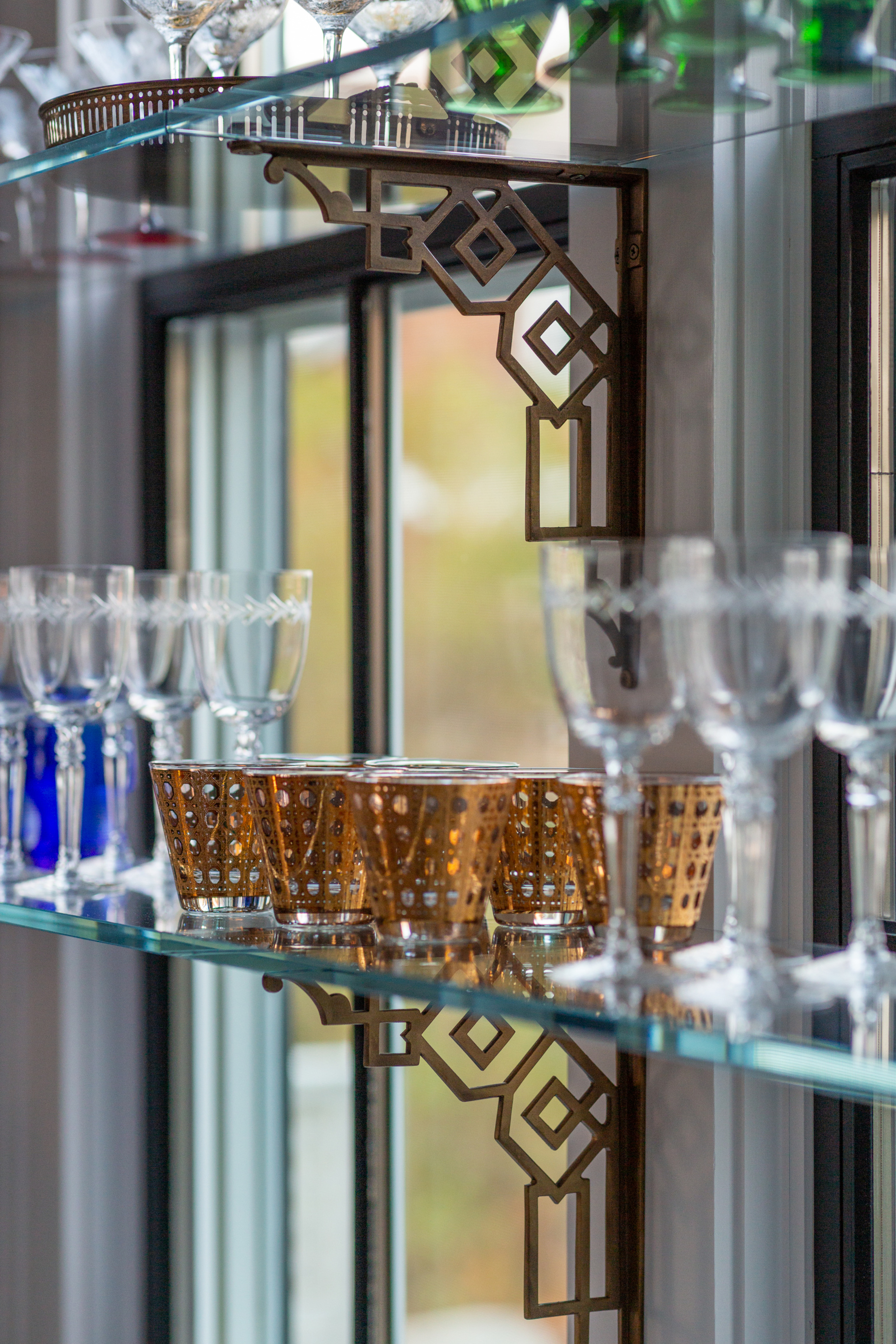 glass shelving in kitchen with barware