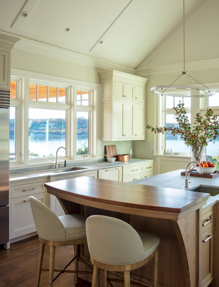 Coastal modern kitchen. Large island with stool seating areas. Ocean views, soft white cabinetry.