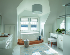 primary bathroom in coastal modern home. Soak tub, tile floor, overhead light fixture and vanity.
