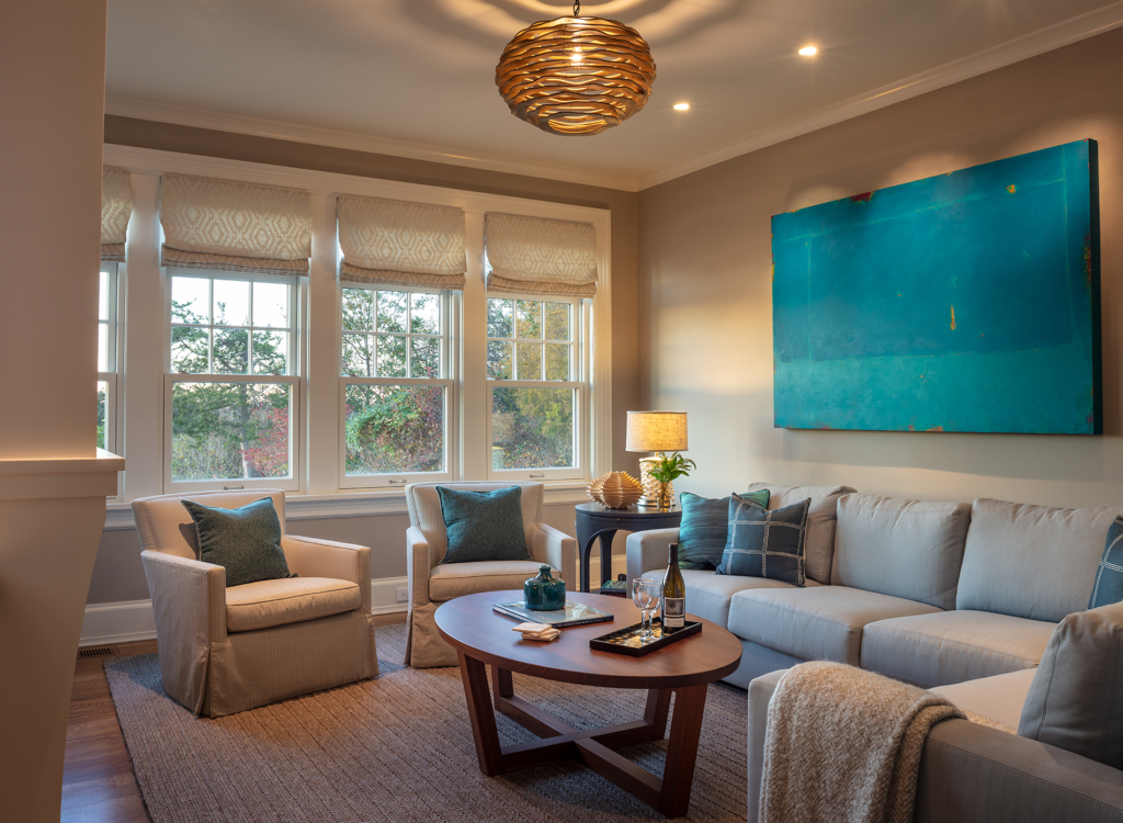 Sitting room with sofa, chairs and coffee table. Overhead lighting.