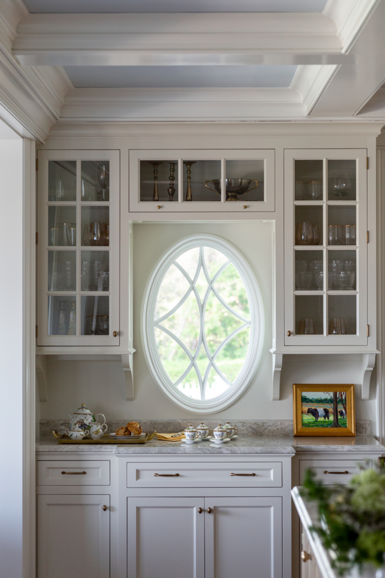 oval window in kitchen with glass cabinetry