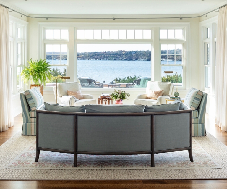 large coastal living room with a sofa and two chairs. Ocean views.