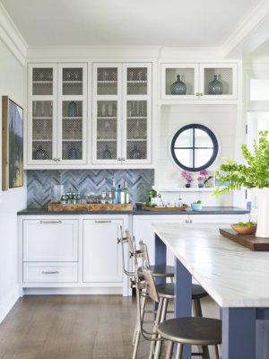coastal kitchen with colorful backsplash, island and circular window details
