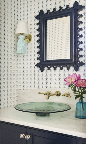 powder room with colorful wallpaper and sconce lighting