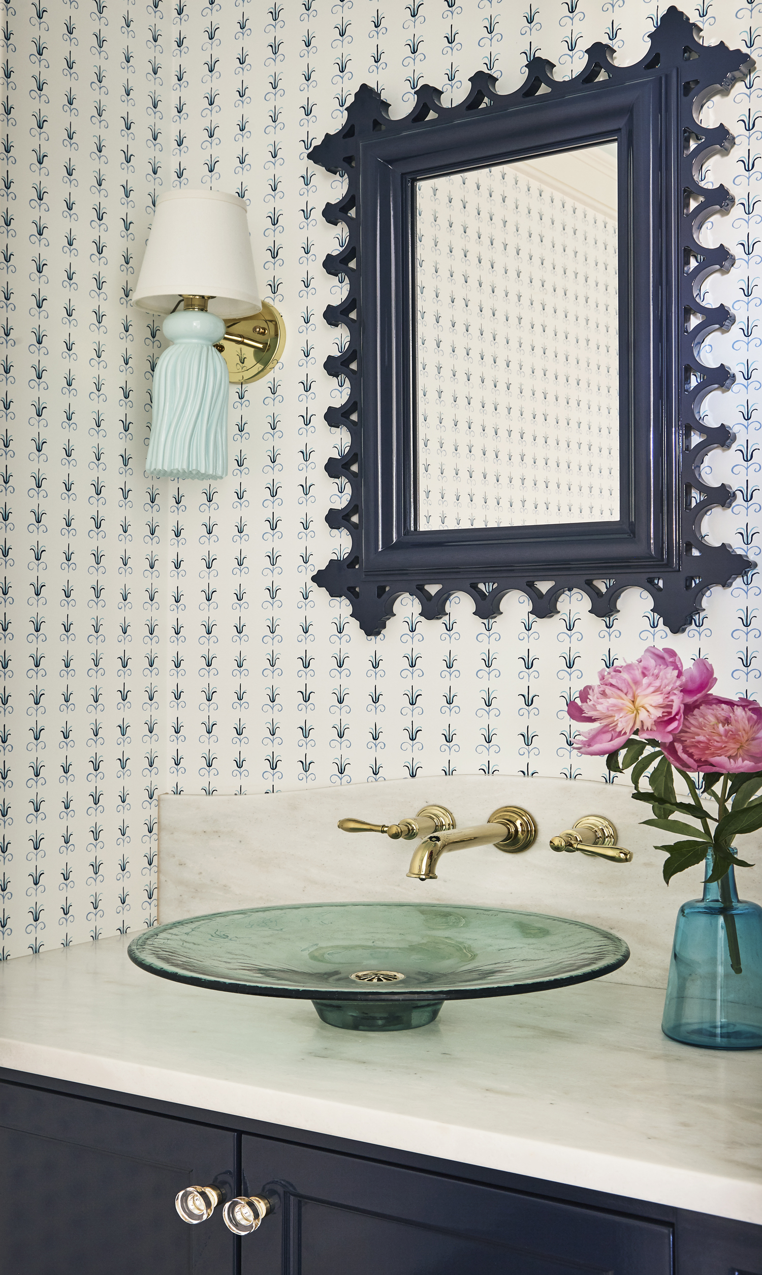 powder room with colorful wallpaper and sconce lighting