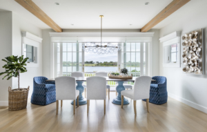 Coastal dining room with bubble chandelier, ocean view, original art, and unique dining chairs.