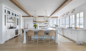 Open-concept kitchen with large island, pendant lights and exposed beams. Kitchen with an ocean view. Accordion windows.