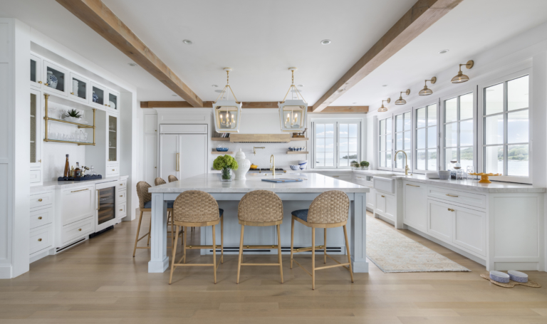 Open-concept kitchen with large island, pendant lights and exposed beams. Kitchen with an ocean view. Accordion windows.