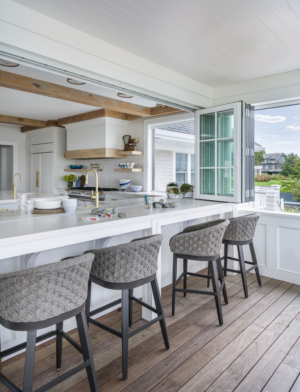 Exterior porch with accordion windows that open to interior kitchen. Outdoor furniture.