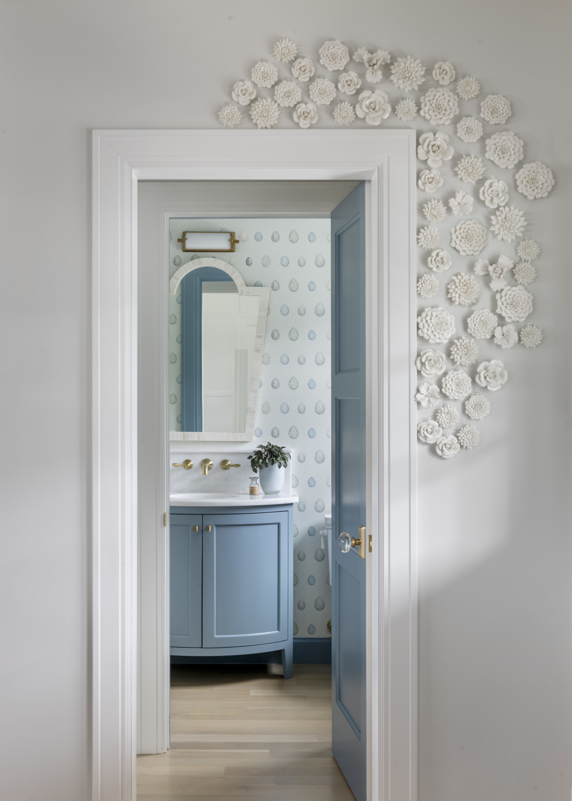 Powder room with colorful wallpaper and original art on the doorframe. Fun powder room.