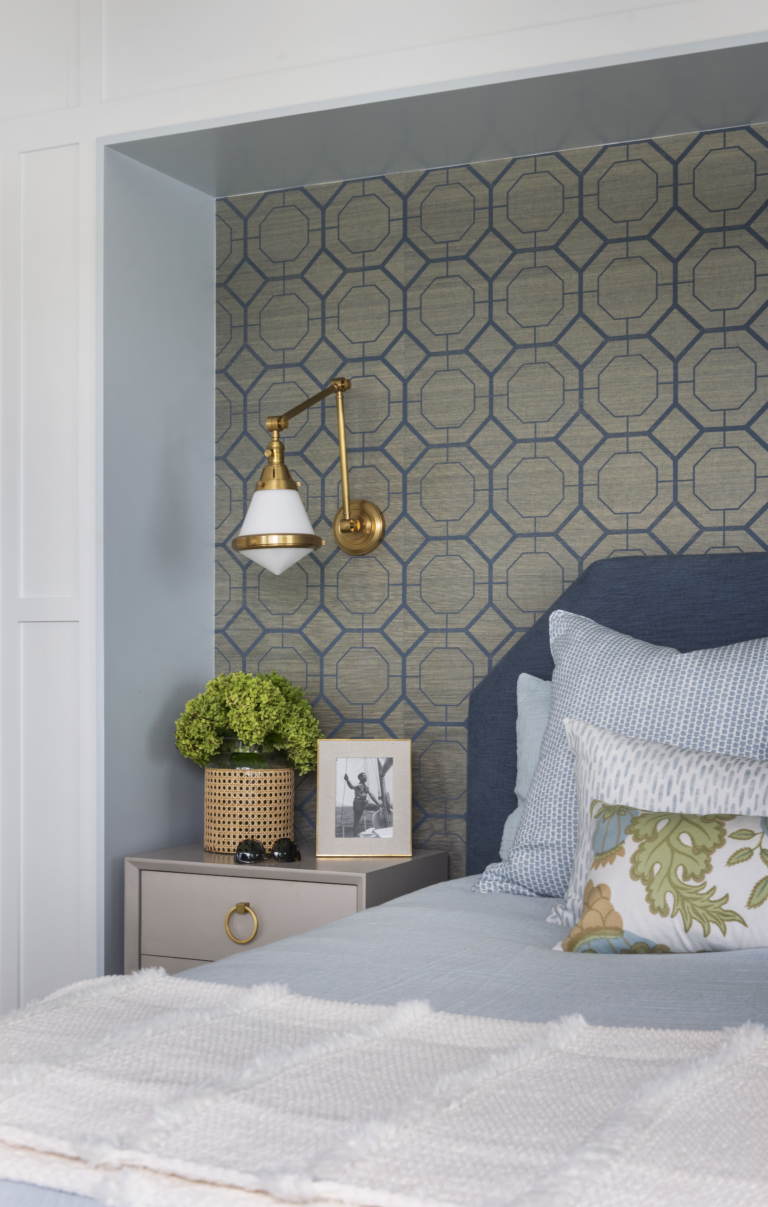 Primary Bedroom wallpaper and sconce. Featuring custom molding, and luxury bedding.