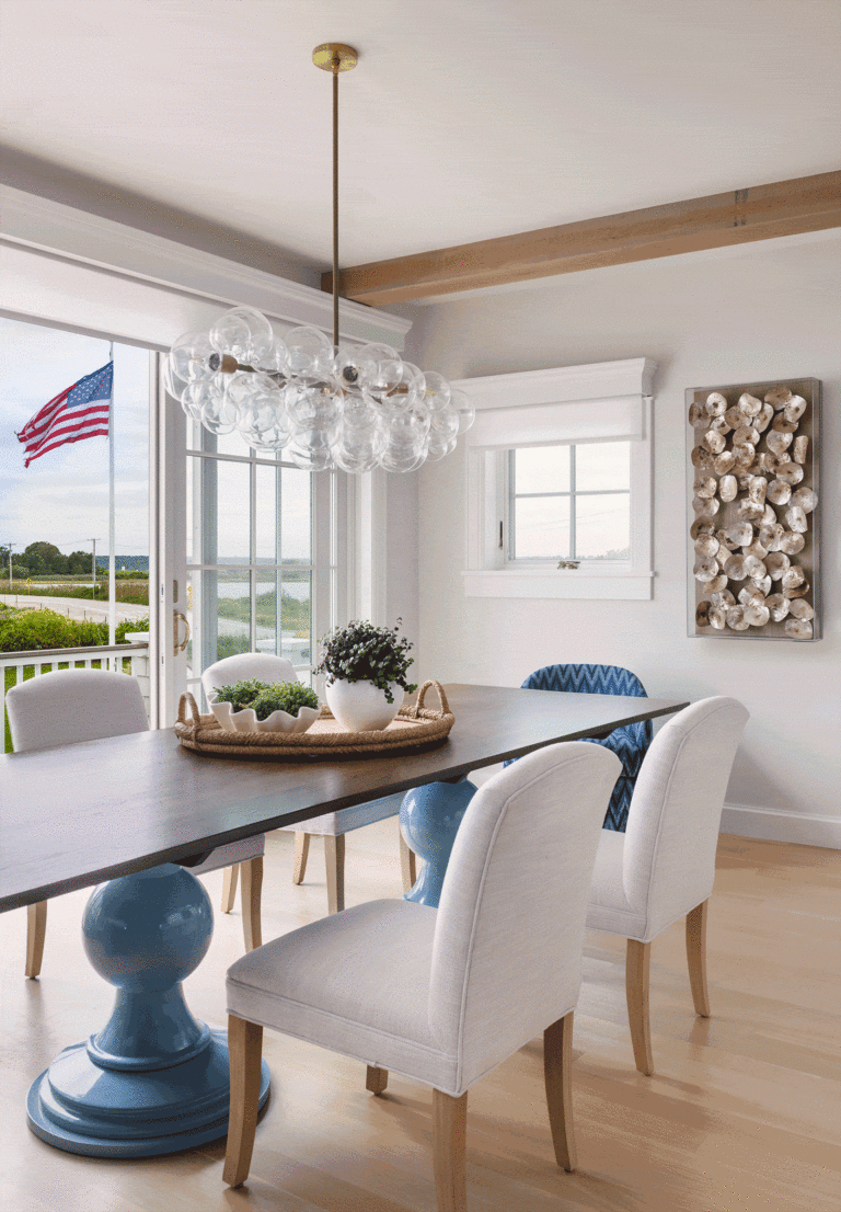 A coastal beach house dining room with a Dunes and Duchess table and flag blowing in the ocean breeze