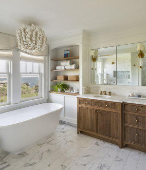 Owner's bathroom with white oak vanity with reeded doors and Palecek Coco Magnolia Hanging Pendant overlooking the ocean view in a modern coastal home designed by Taste Design Inc and Paul Weber Architecture near Newport RI