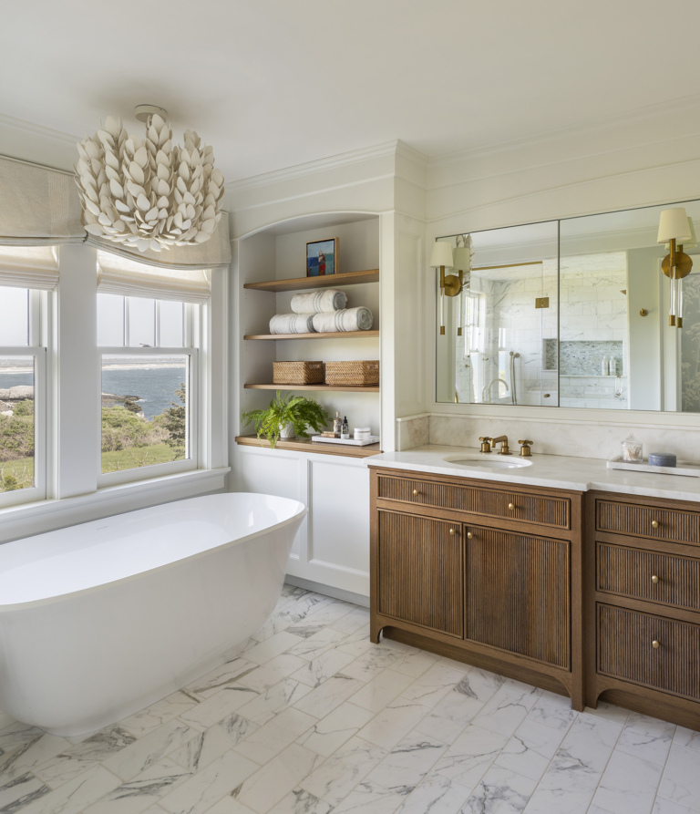 Owner's bathroom with white oak vanity with reeded doors and Palecek Coco Magnolia Hanging Pendant overlooking the ocean view in a modern coastal home designed by Taste Design Inc and Paul Weber Architecture near Newport RI
