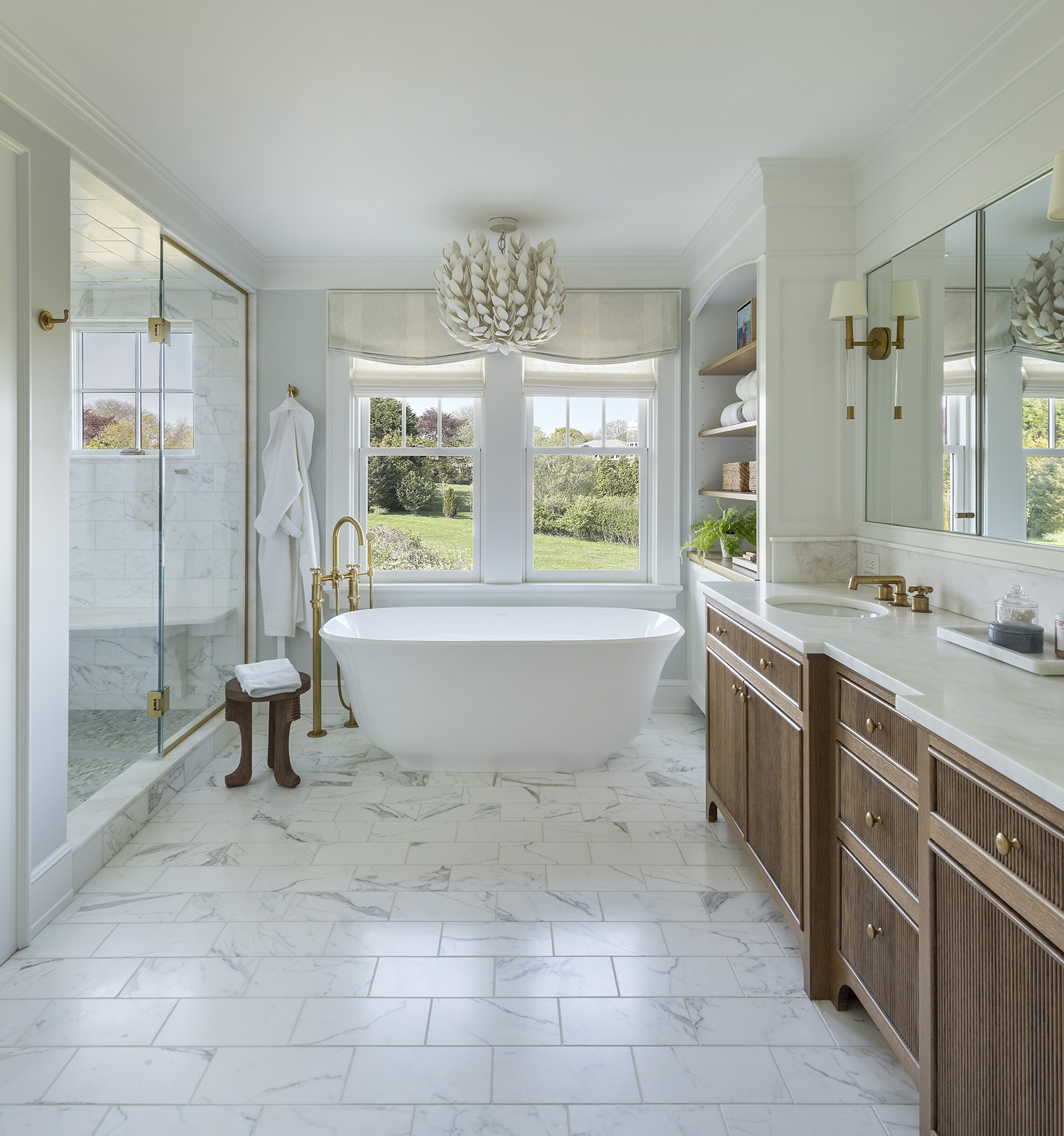 Owner's bathroom with standing Victoria + Albert tub and vanity with reeded doors overlooking the ocean in a modern coastal home designed by Taste Design Inc and Paul Weber Architecture near Newport RI