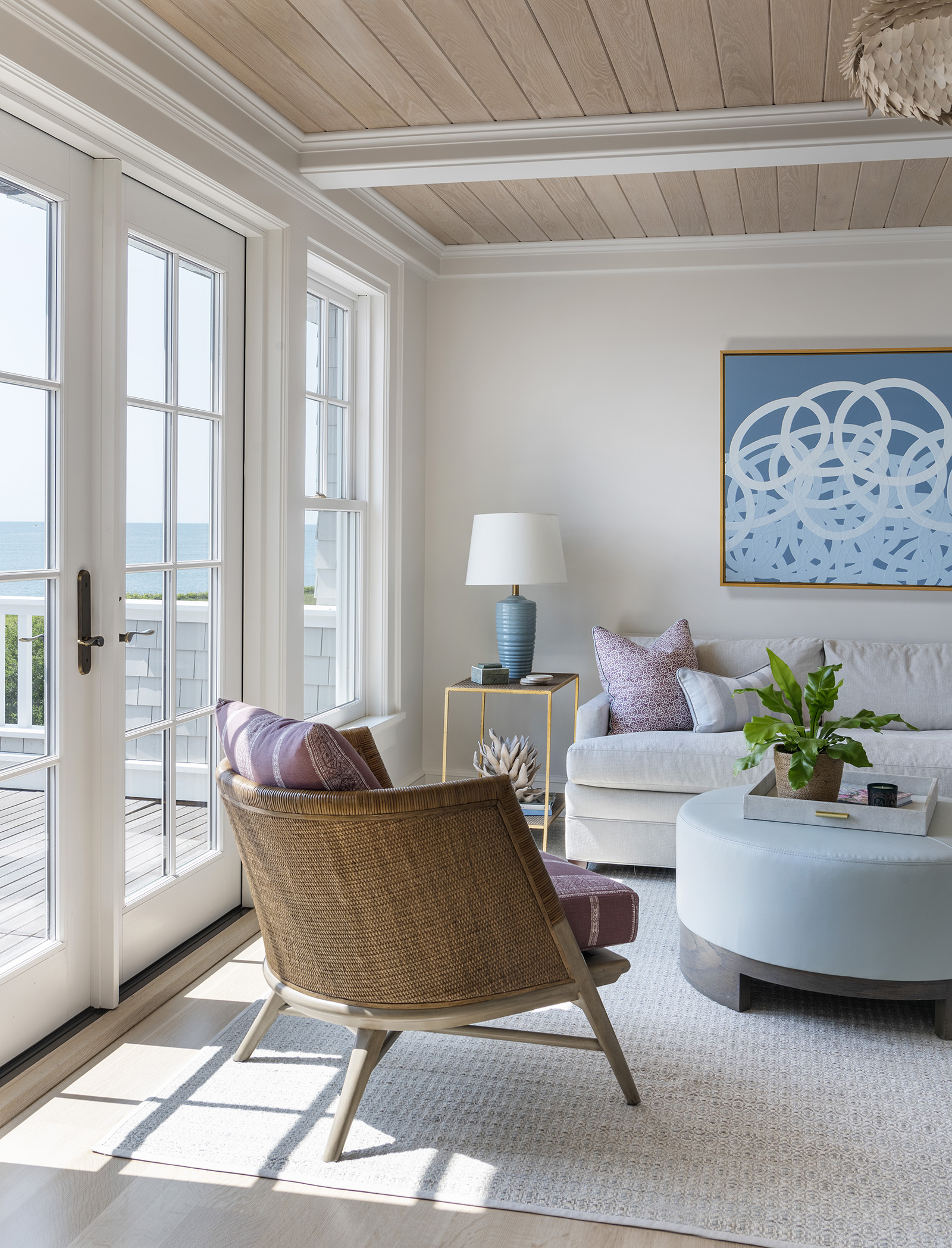 A lavender, blue and white sitting room with an ocean view in the owner's suite of a modern coastal home designed by Taste Interior Design