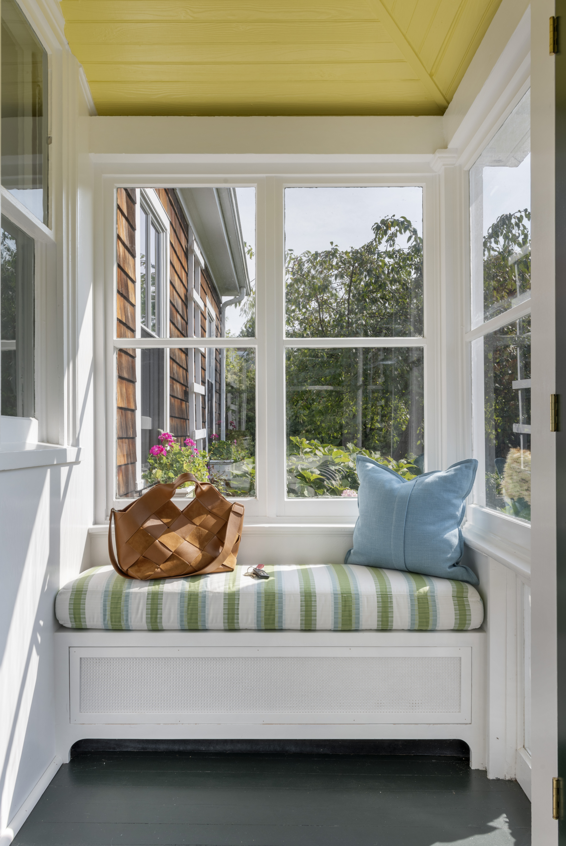 A window seat in a breezeway of a summer cottage