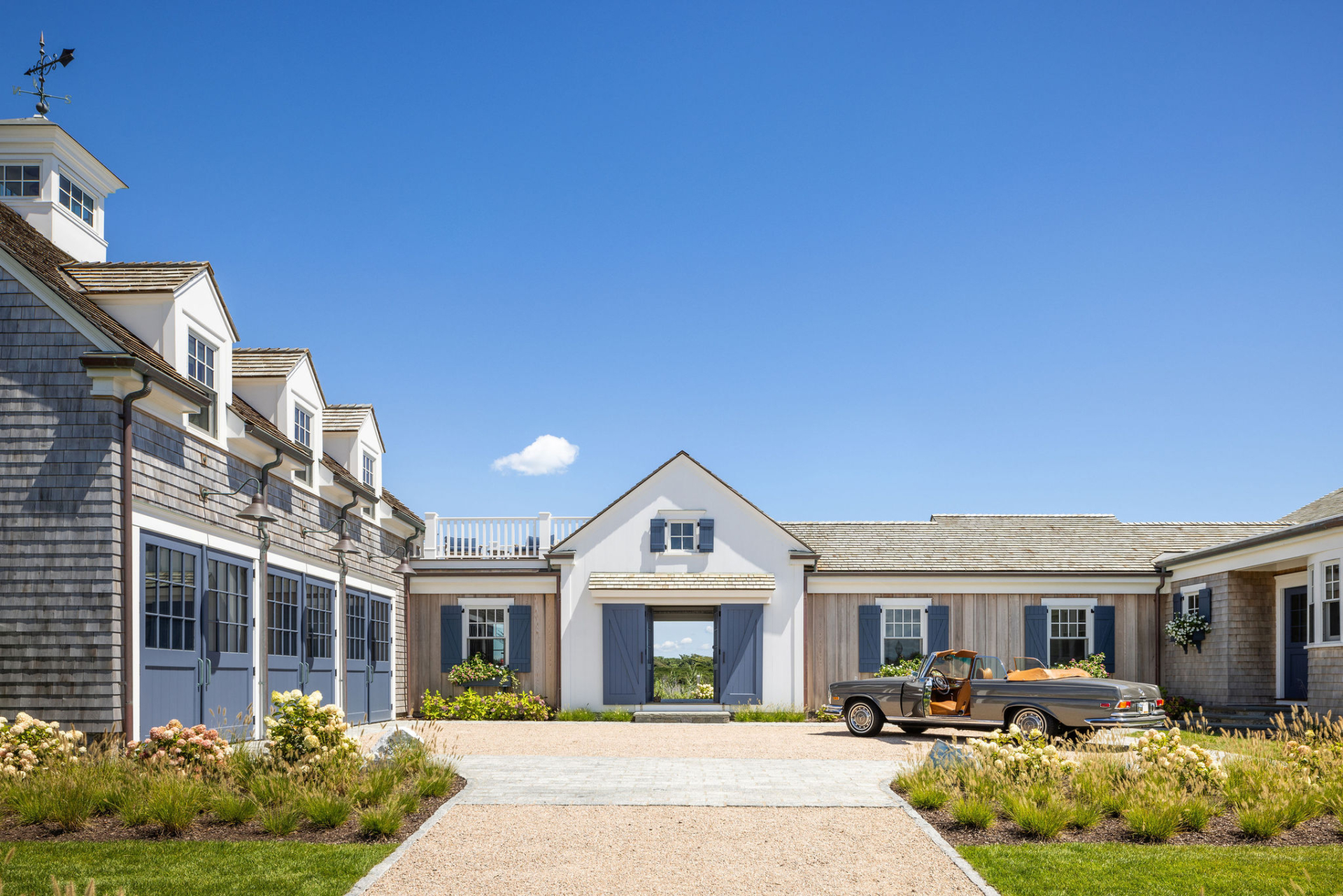 Courtyard view of Ocean Lodge highlighting the carriage house, original architectural scale, and timeless coastal detailing, preserved and redesigned by Taste Design Inc.