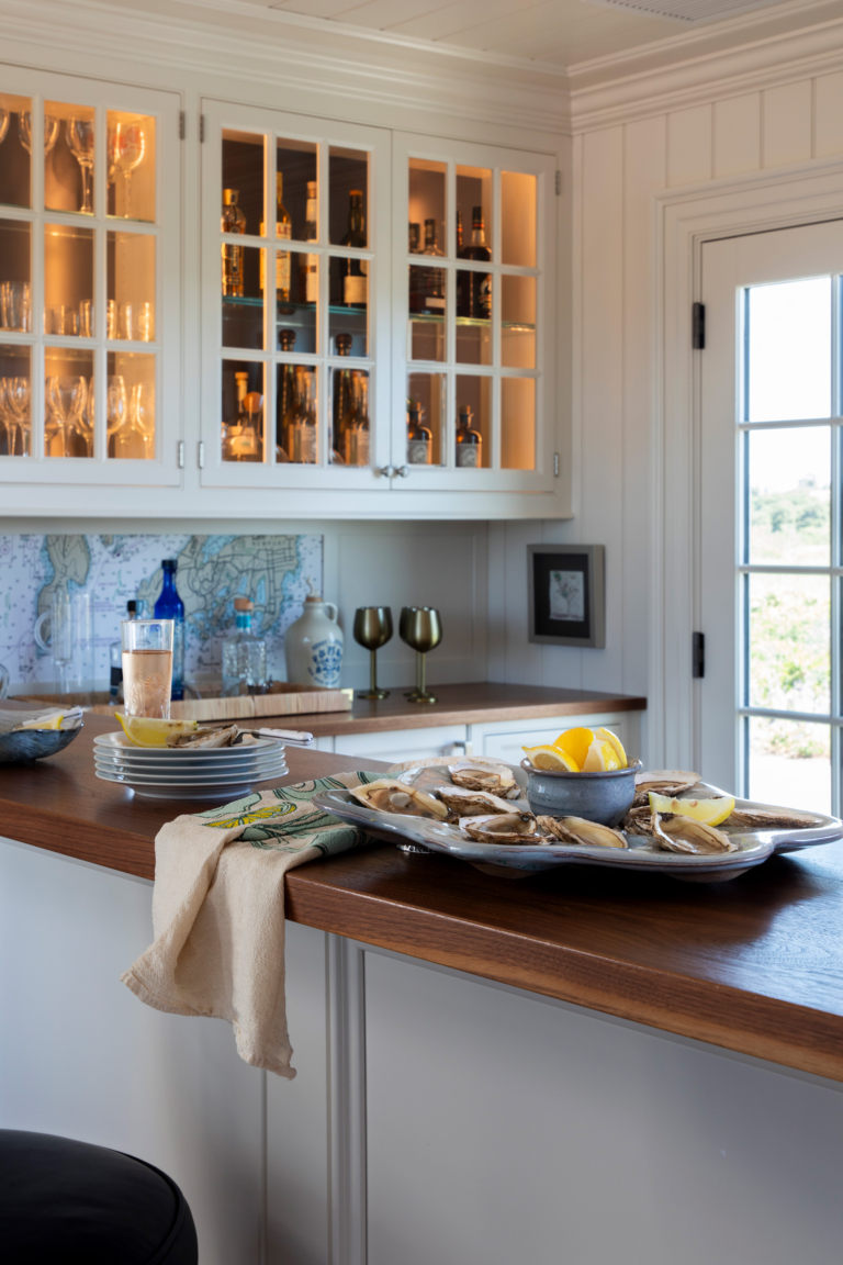 Detail of the Ocean Lodge bar with open shelves and a tray of fresh oysters, reflecting refined coastal hospitality and classic cabinetry design.