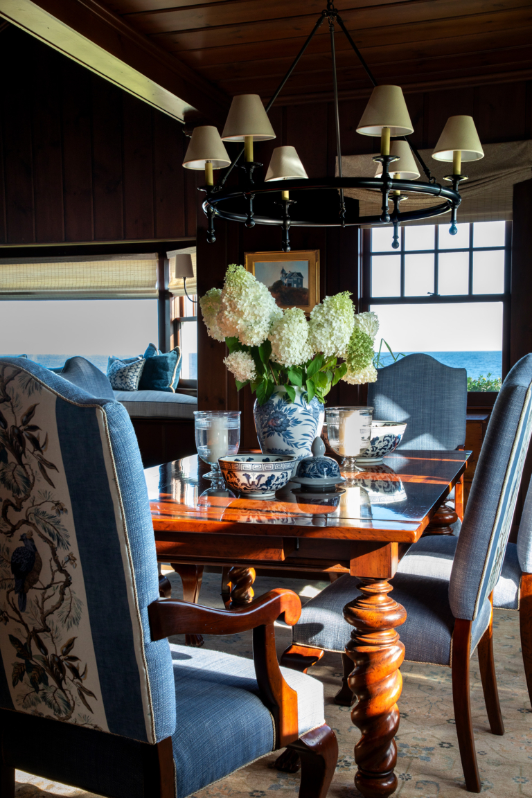 Formal dining room at Ocean Lodge featuring antique-style dining chairs, carved wood table, and ocean-facing windows.