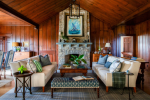 Living room at Ocean Lodge featuring twin sofas, navy textiles, and warm wood tones that echo Newport’s refined coastal aesthetic.