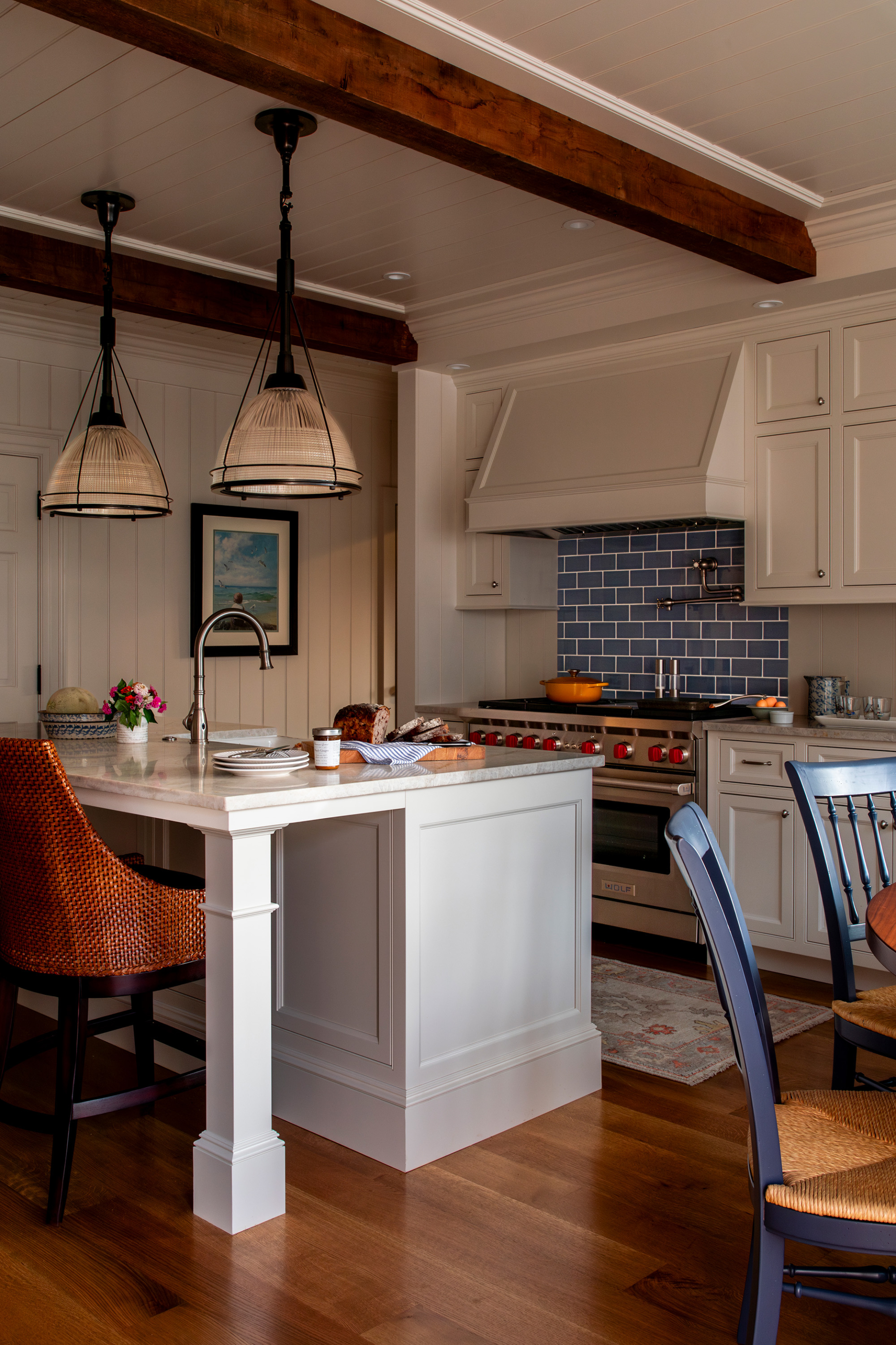 A coastal cottage kitchen with a blue tile backsplash and natural wood beams in the ceiling.