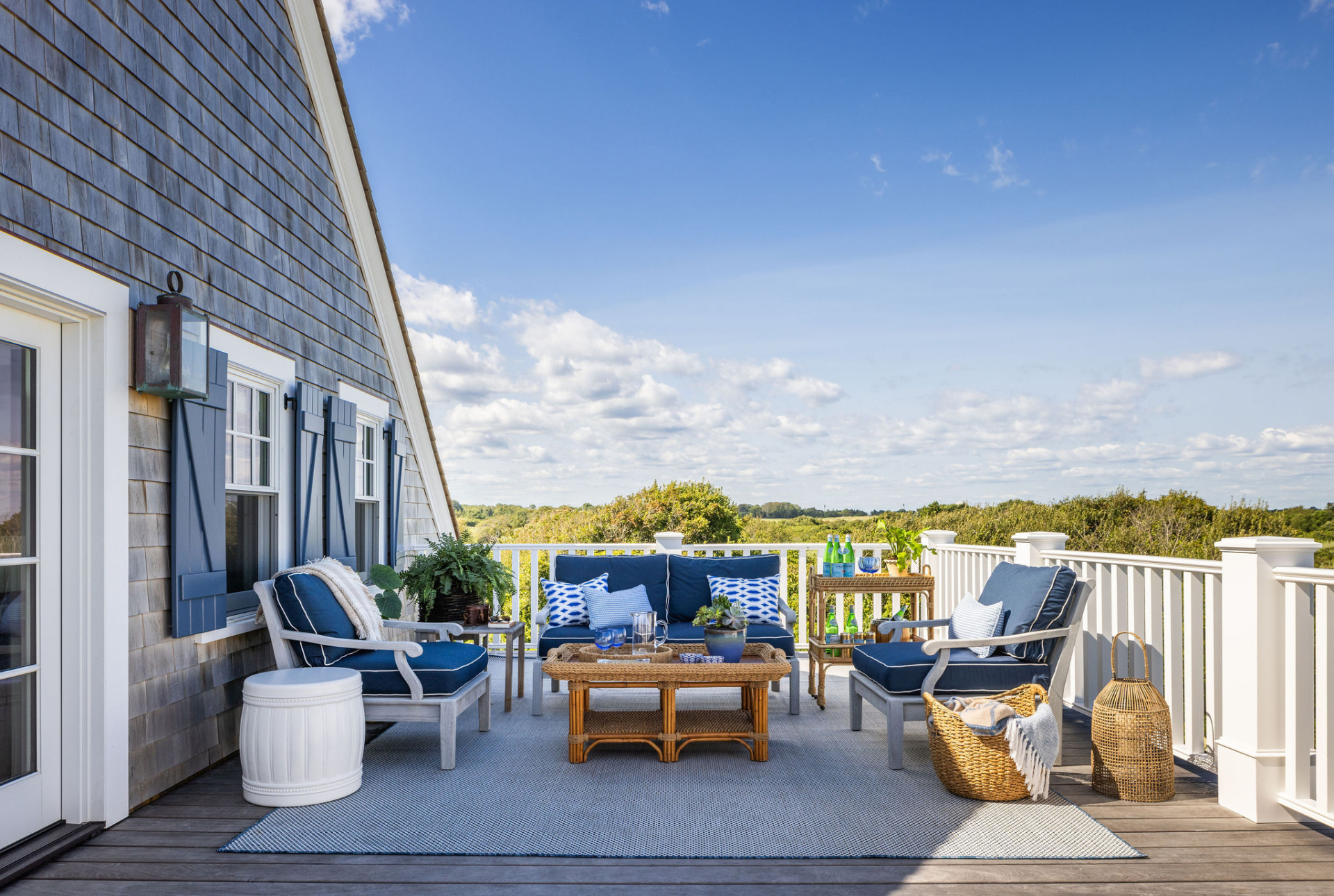Rooftop terrace at Ocean Lodge with sweeping views, classic blue-and-white furnishings, and relaxed coastal styling designed by Taste Design Inc.