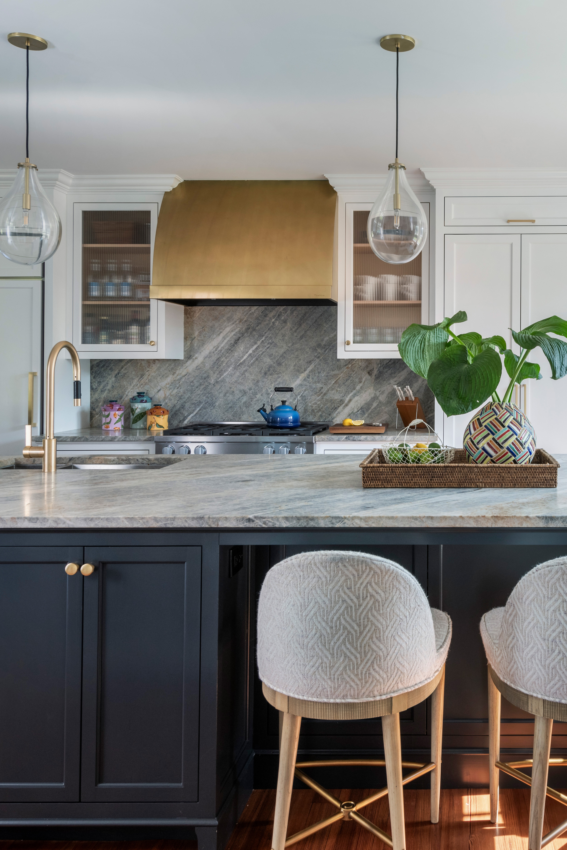 A kitchen island with Farrow and Ball painted cabinetry and quartzite countertops