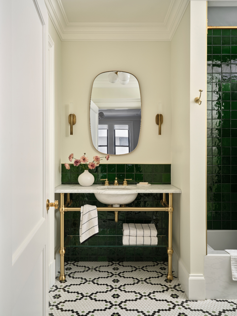 Green tile bathroom vanity with brass fixtures in Upper West Side pet-friendly apartment renovation.