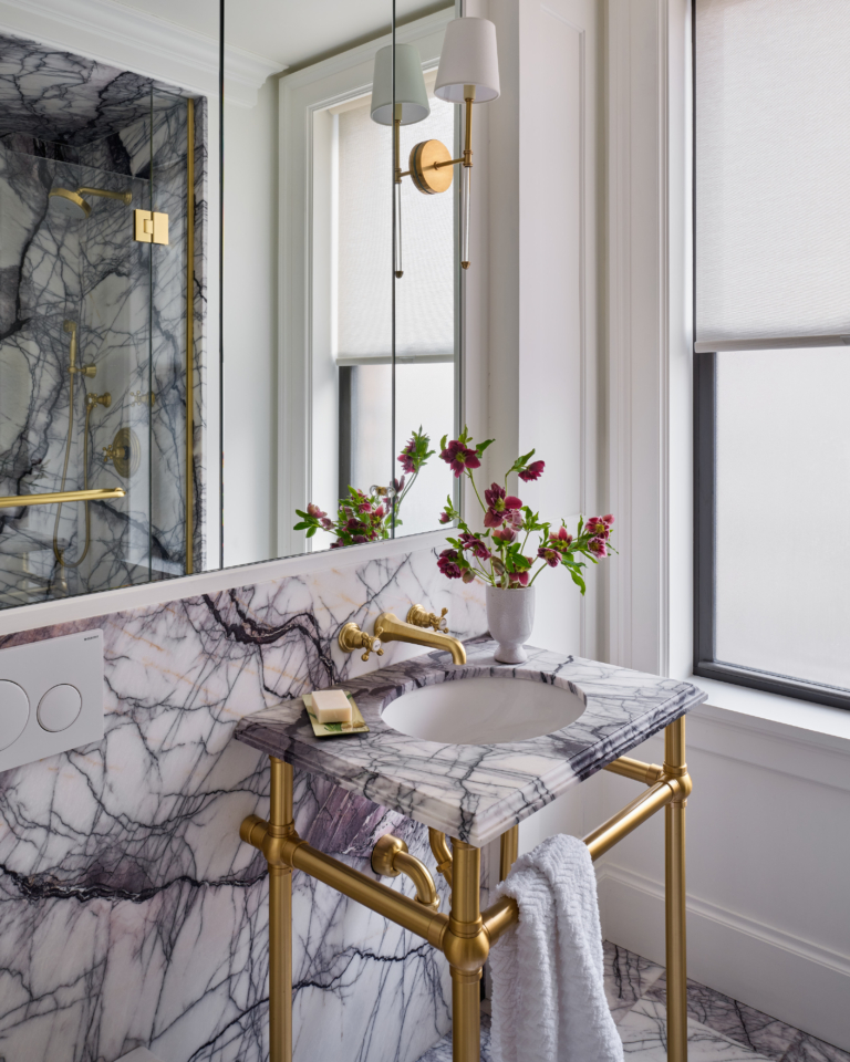 Detail of marble vanity with brass fixtures and flowers in UWS pet-friendly apartment renovation.