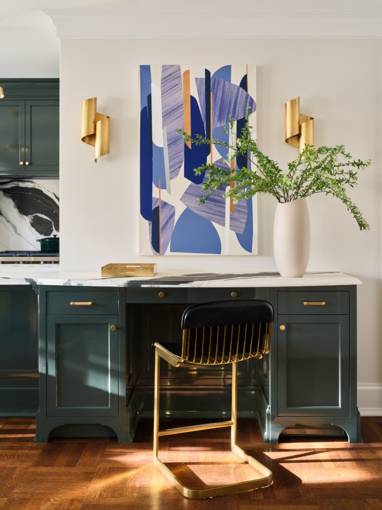 Built-in desk with navy cabinetry, brass accents, and modern artwork in Upper West Side apartment renovation.