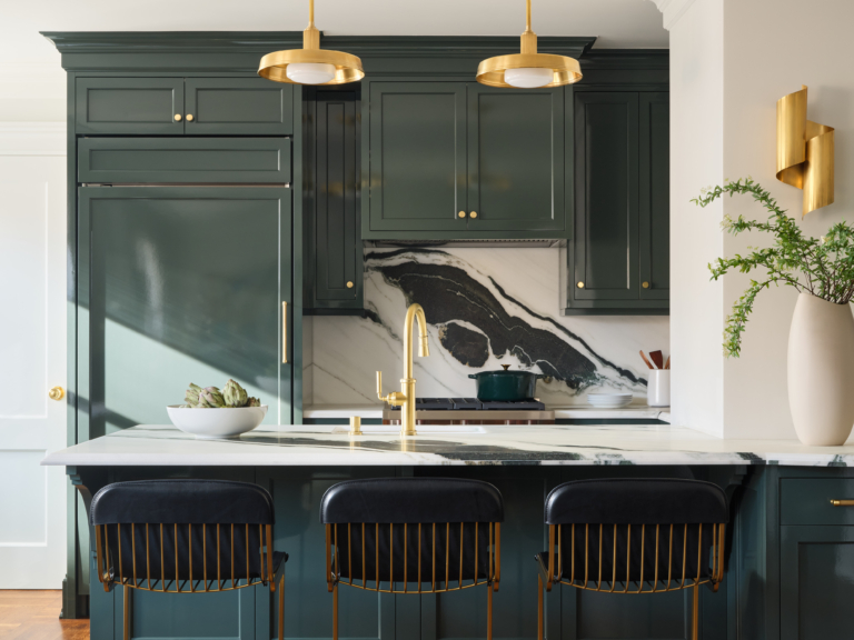 Detail of marble backsplash and navy cabinetry with brass lighting in UWS pet-friendly apartment renovation by Taste Design Inc.