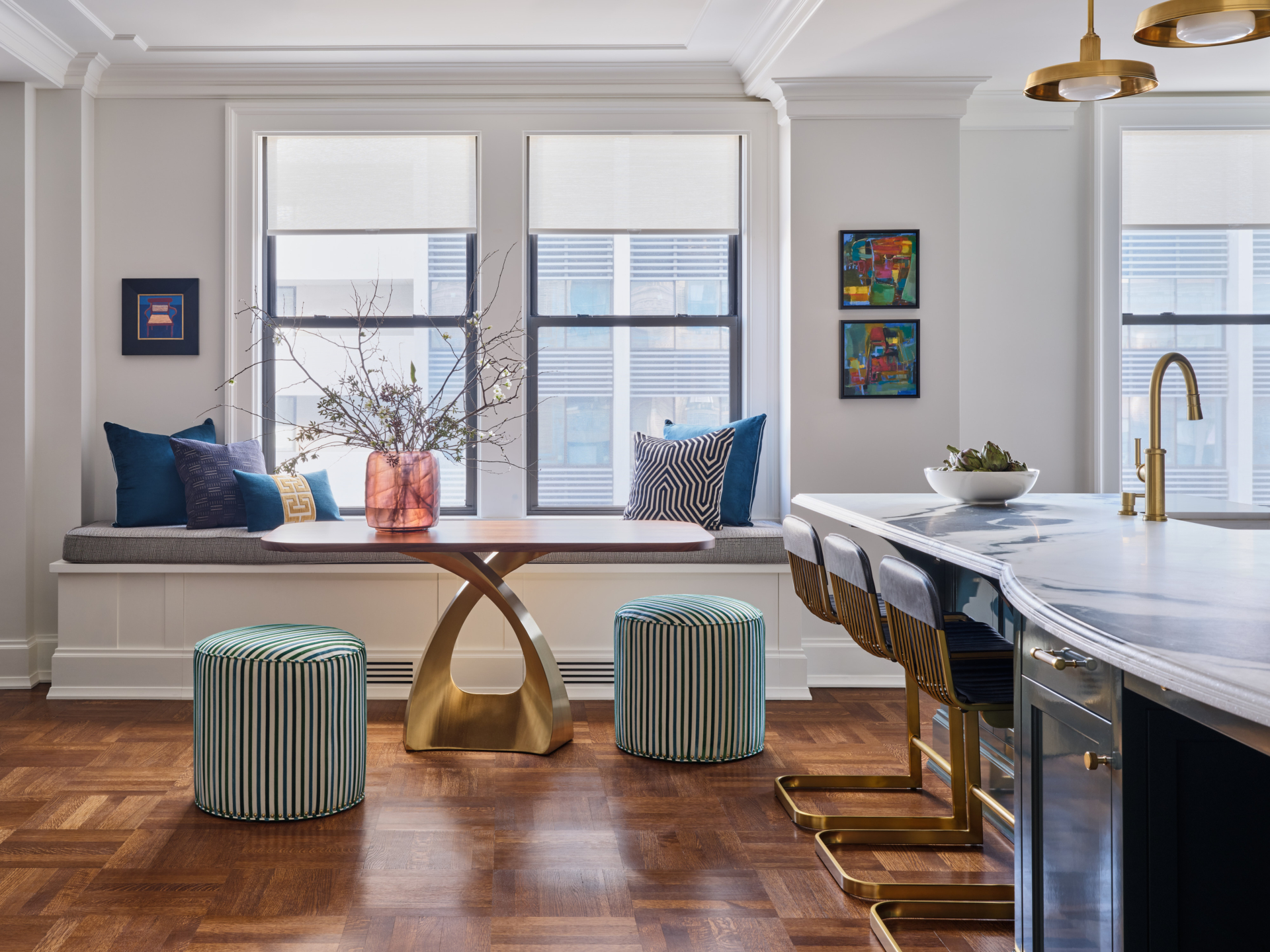 Window seat with colorful pillows and dining table in Upper West Side apartment renovation.