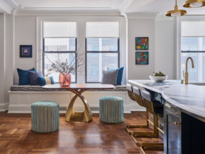 Window seat with colorful pillows and dining table in Upper West Side apartment renovation.