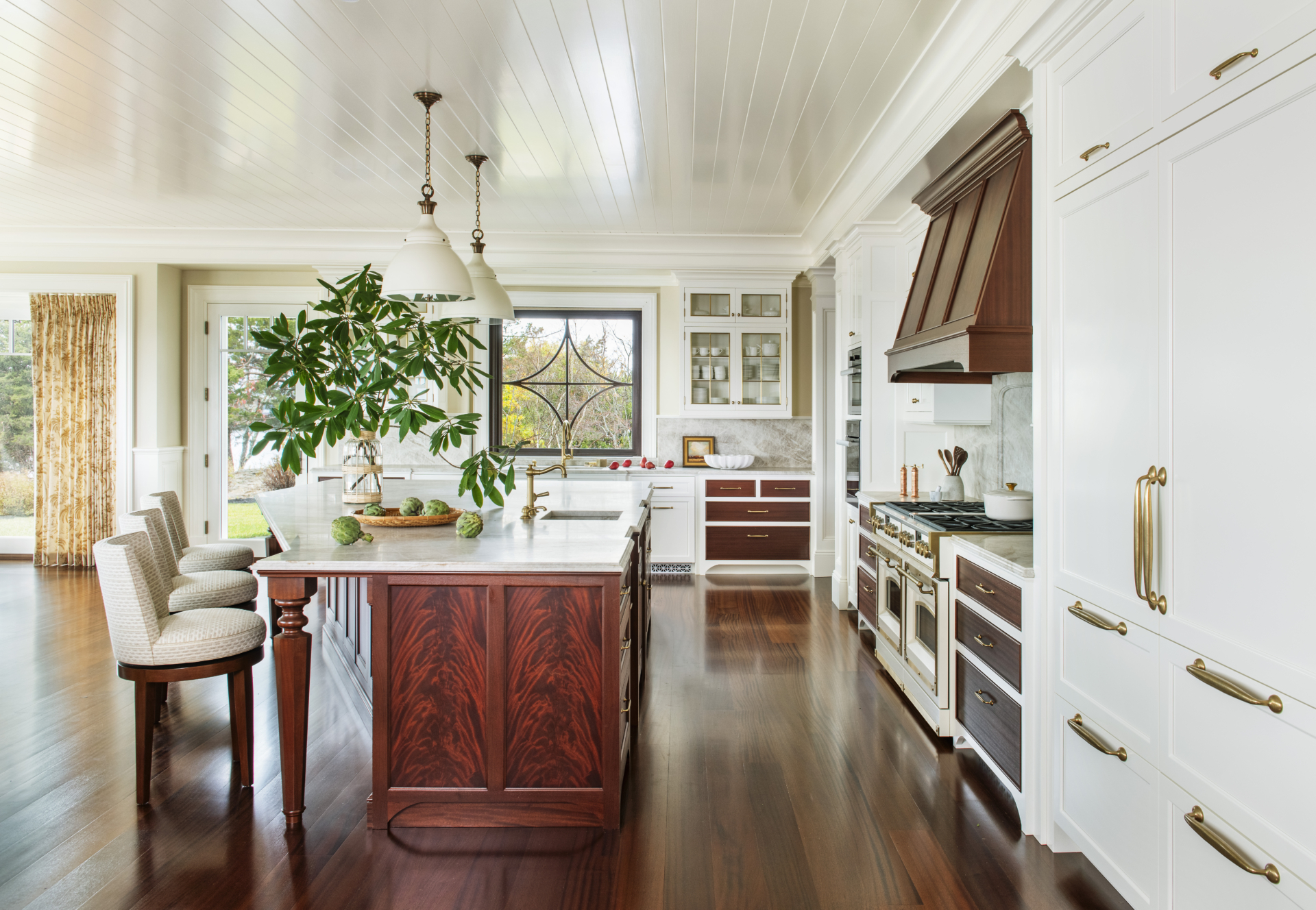 A luxury kitchen with mahogany wood and white cabinetry by Taste Design Inc.