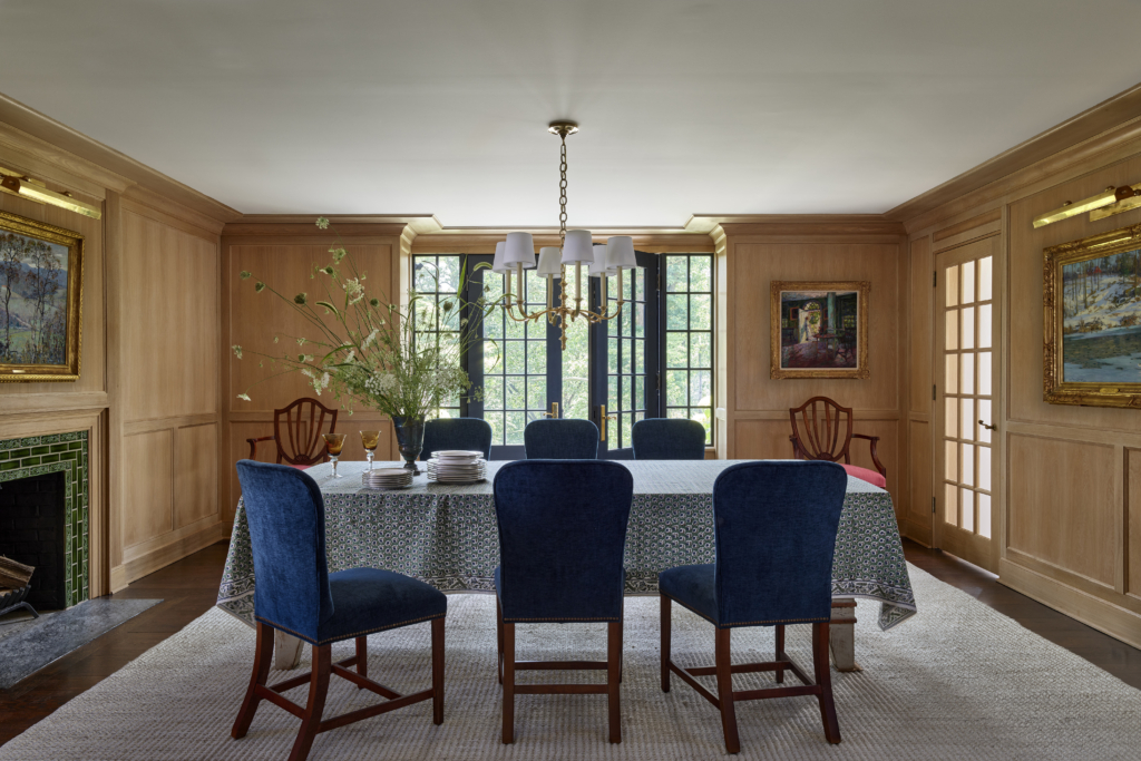 A dining room with blue chairs and oak paneling