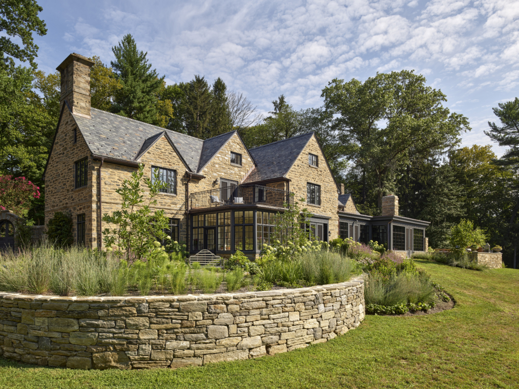 Back of a home with a garden surrounded by a wall