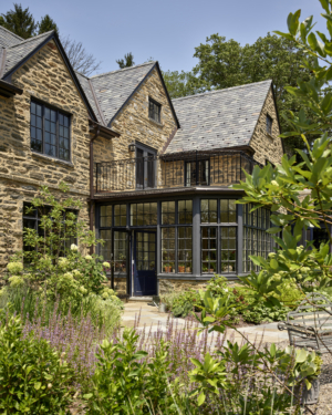 A garden entrance to a solarium at the back of a stone home