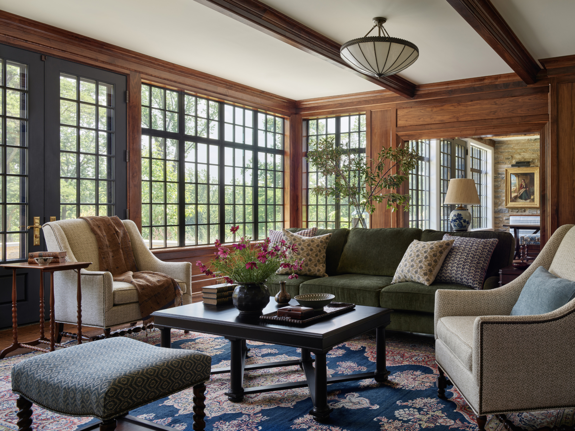 A living room with green sofa and leaded glass windows