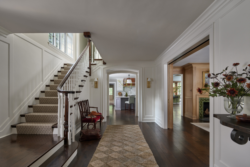 The hallway of a home with an antique bench