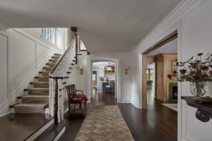 The hallway of a home with an antique bench