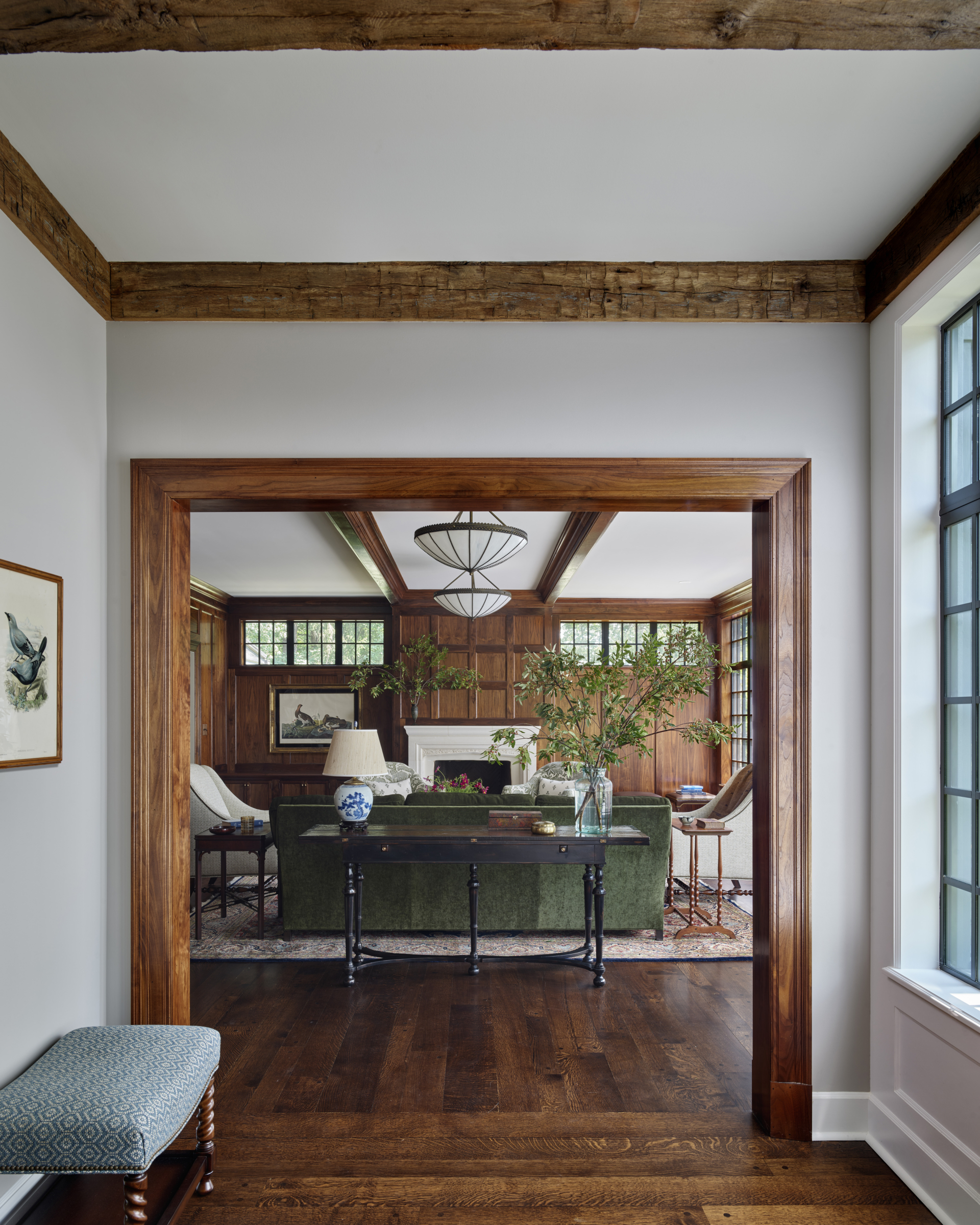 The doorway opening to a wood paneled living room