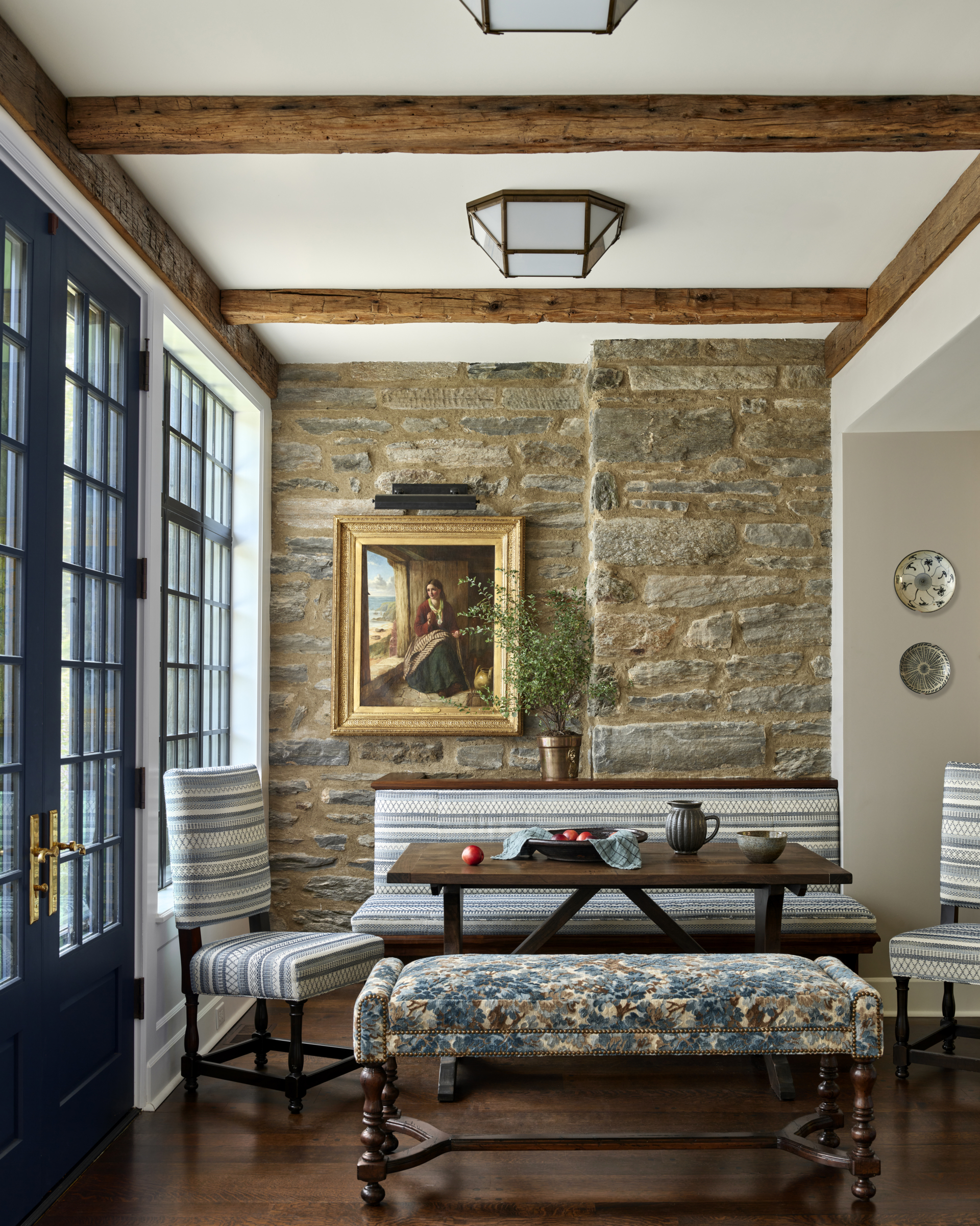 A kitchen nook with a banquette and fieldstone wall