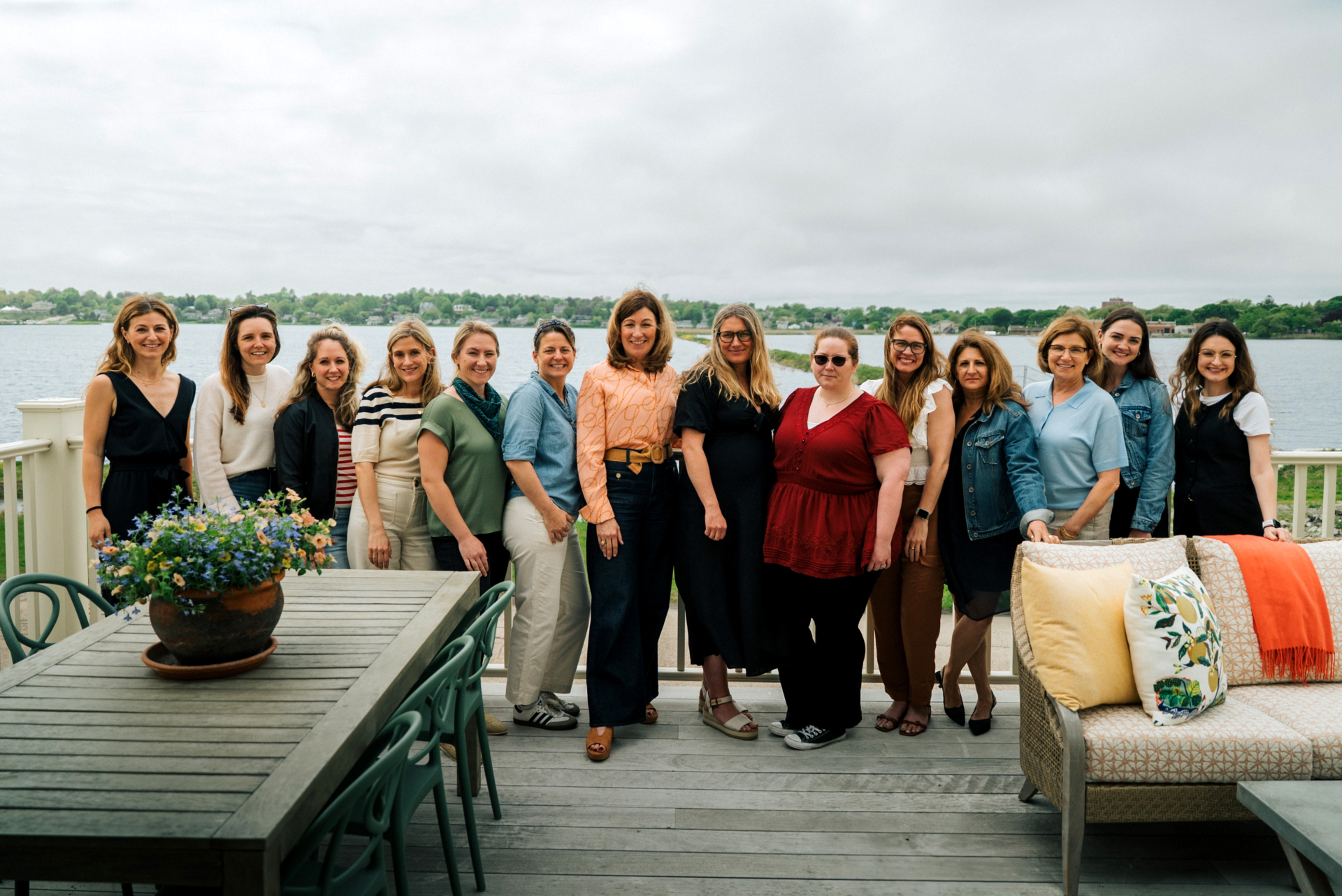 Patti Watson and employees of Taste Design Inc. on a deck with water behind.