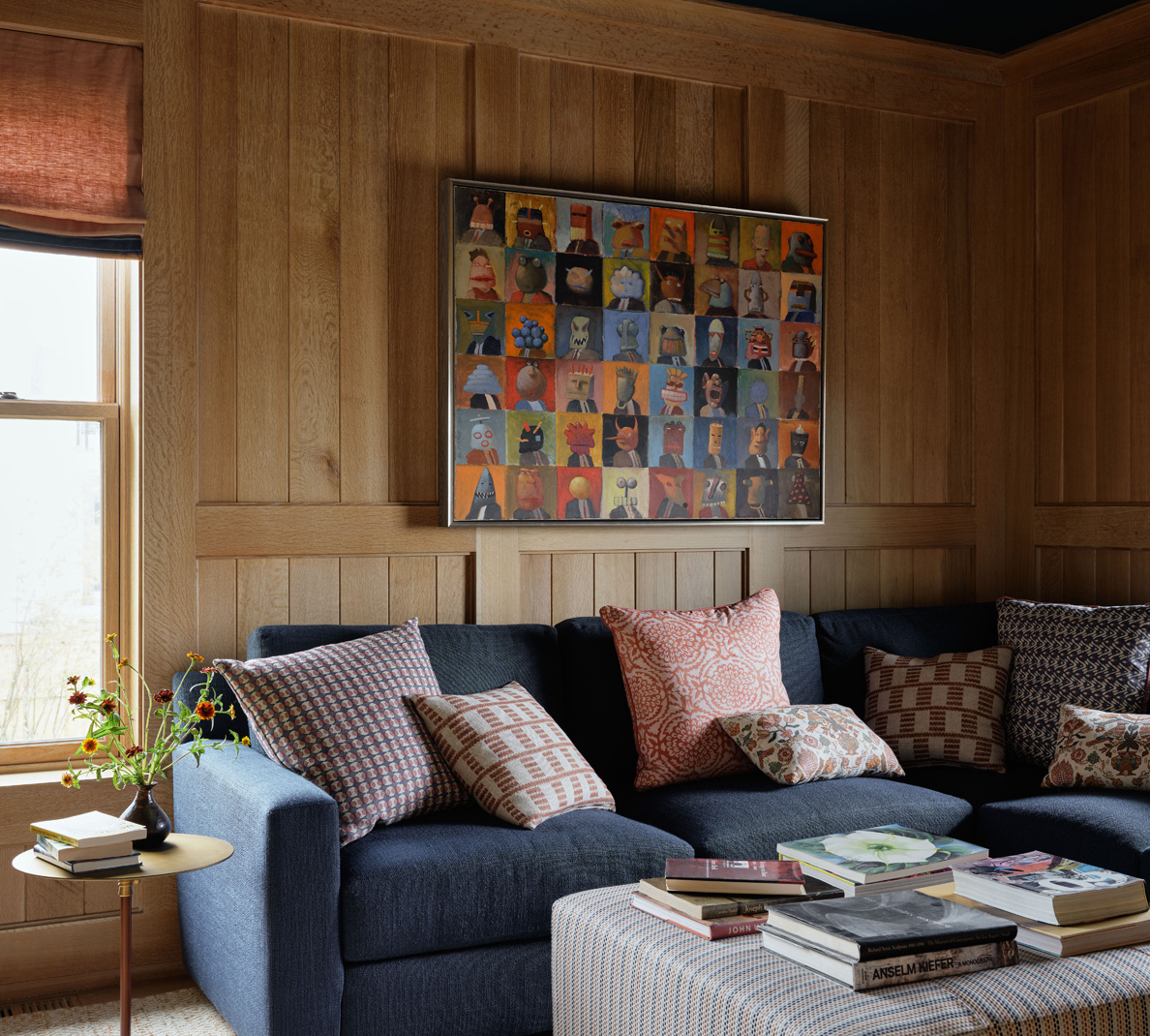 An oak paneled room with dark blue ceiling and sofa.