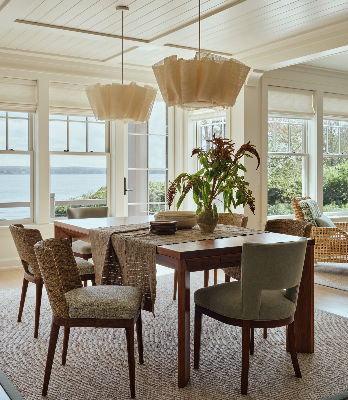 A dining room with oak table and natural textured statement lighting.